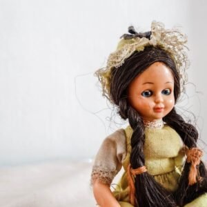 Close-up of a vintage doll wearing traditional attire, featuring intricate lace details.